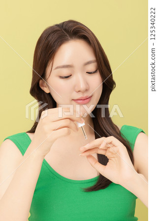 Portrait of young woman taking care of her nails 125340222