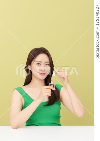 Portrait of young woman taking care of her nails 125340227