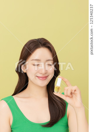 Portrait of young woman posing with nail polish Portrait of young woman posing with nail polish 125340237