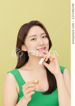 Cropped view of young woman applying nail polish to nails Cropped view of young woman applying nail polish to nails 125340246