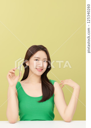 Cropped view of young woman taking care of her nails with nail clippers Cropped view of young woman taking care of her nails with nail clippers 125340260