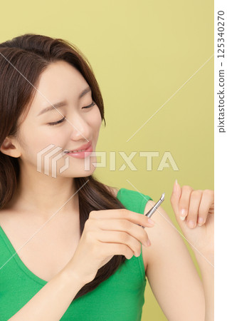 Cropped view of young woman taking care of her nails with nail clippers 125340270