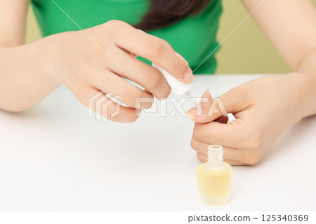 Woman's hands applying nail nourishment 125340369