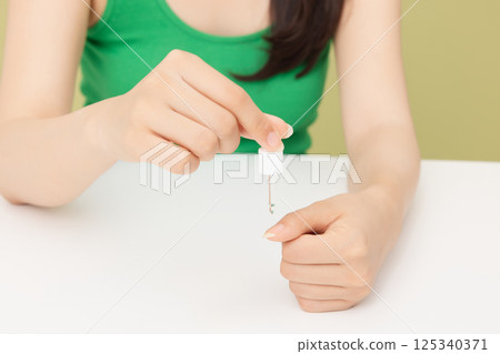 Woman's hands applying nail nourishment 125340371