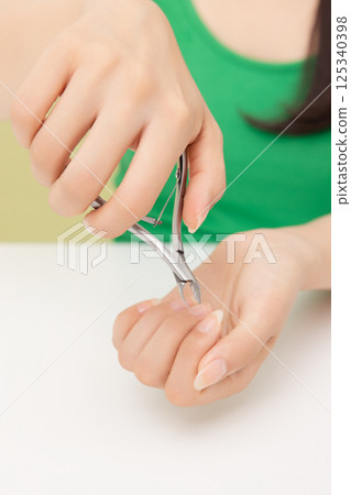 Woman's hands applying hand cream 125340398