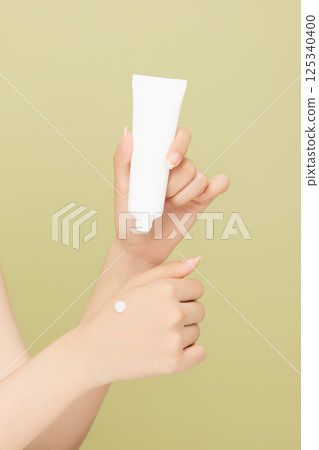 Woman's hands applying hand cream 125340400