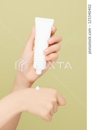 Woman's hands applying hand cream 125340402