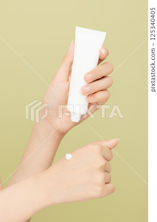Woman's hands applying hand cream 125340405