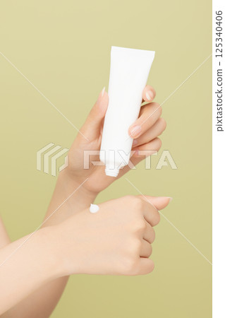 Woman's hands applying hand cream 125340406