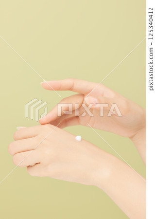 Woman's hands applying hand cream 125340412
