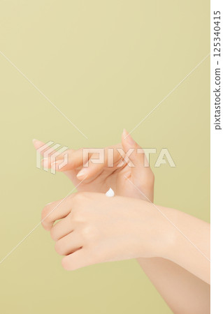 Woman's hands applying hand cream 125340415