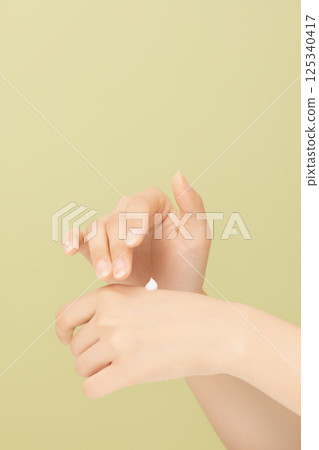 Woman's hands applying hand cream 125340417