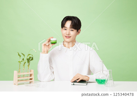 A young man posing with basic cosmetics made using plants A young man posing with basic cosmetics made using plants 125340478
