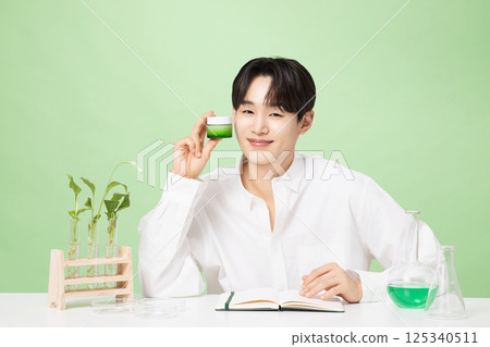 A young man posing with basic cosmetics made using plants A young man posing with basic cosmetics made using plants 125340511