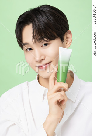 A young man posing with basic cosmetics made using plants A young man posing with basic cosmetics made using plants 125340514