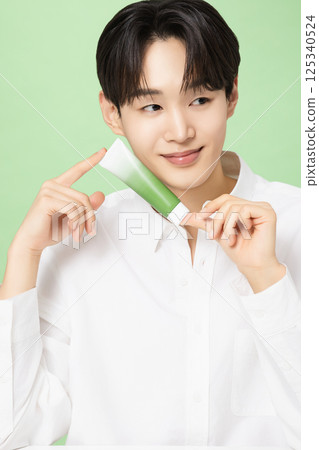 A young man posing with basic cosmetics made using plants A young man posing with basic cosmetics made using plants 125340524