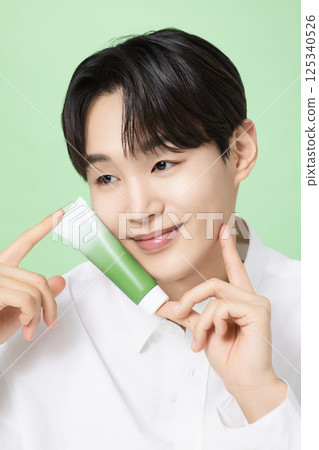 A young man posing with basic cosmetics made using plants A young man posing with basic cosmetics made using plants 125340526