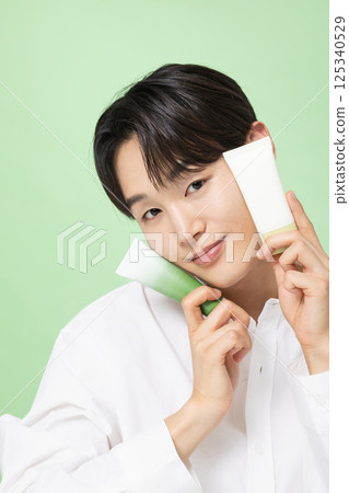 A young man posing with basic cosmetics made using plants 125340529