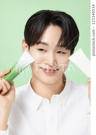 A young man posing with basic cosmetics made using plants 125340534