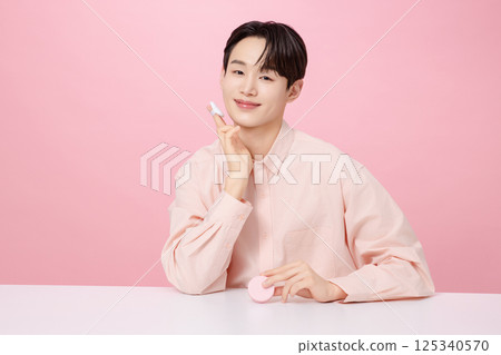 Portrait of a young man posing while holding a cushion 125340570
