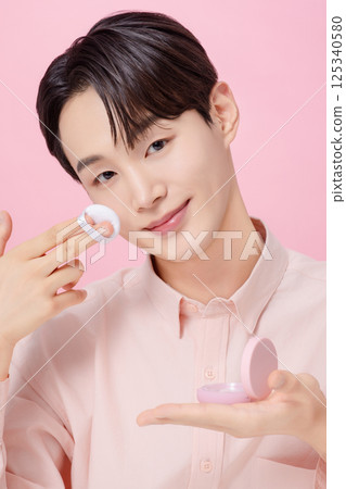 Portrait of a young man posing while holding a cushion Portrait of a young man posing while holding a cushion 125340580