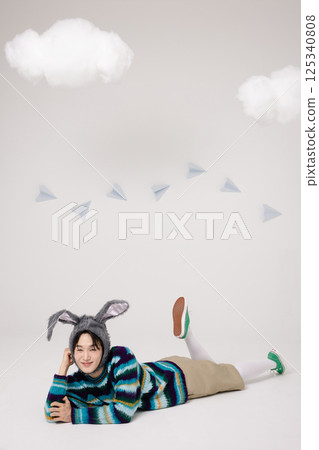 Playful pose of a man wearing a rabbit hat and returning to childhood Playful pose of a man wearing a rabbit hat and returning to childhood 125340808