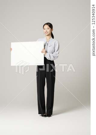 A neat-looking woman in her 20s holding a piece of copyspace paper 125340914