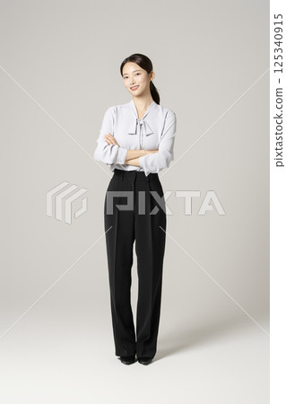 A young woman in her 20s standing in neat clothes 125340915