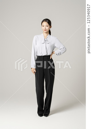 A young woman in her 20s standing in neat clothes 125340917