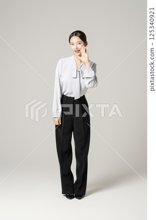A young woman in her 20s standing in neat clothes 125340921