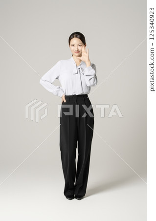 A young woman in her 20s standing in neat clothes 125340923