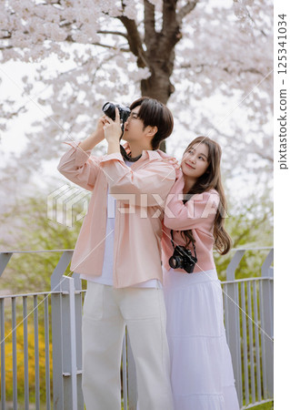 A lovely couple enjoying a date in a park with spring flowers in full bloom 125341034