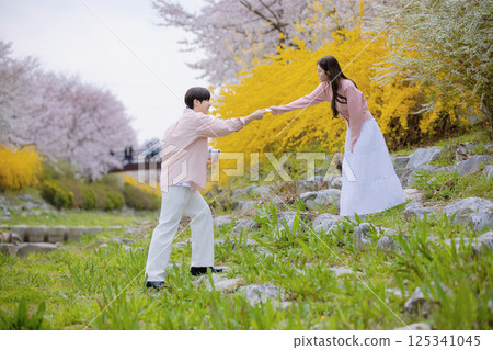 A lovely couple enjoying a date in a park with spring flowers in full bloom 125341045