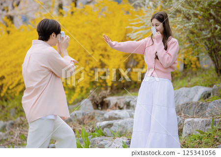 A lovely couple enjoying a date in a park with spring flowers in full bloom 125341056