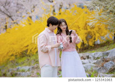 A lovely couple enjoying a date in a park with spring flowers in full bloom 125341063
