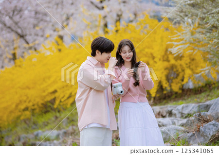 A lovely couple enjoying a date in a park with spring flowers in full bloom 125341065