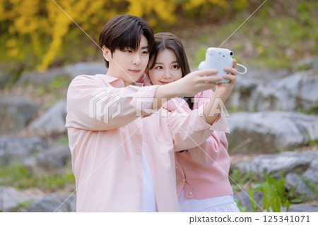 A lovely couple enjoying a date in a park with spring flowers in full bloom 125341071