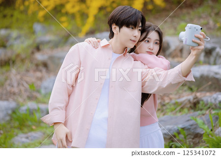 A lovely woman taking the photo of her life with spring flowers in the background 125341072