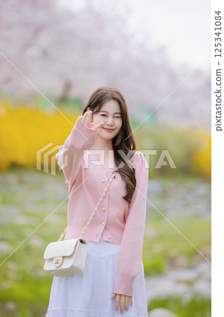 A lovely woman taking the photo of her life with spring flowers in the background 125341084