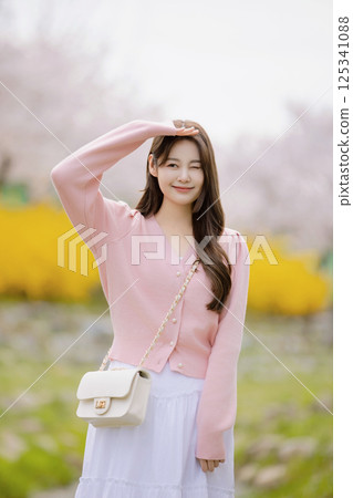 A lovely woman taking the photo of her life with spring flowers in the background A lovely woman taking the photo of her life with spring flowers in the background 125341088