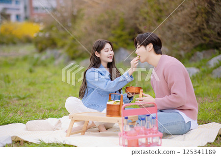 A couple enjoying a date while having a picnic in the park 125341189