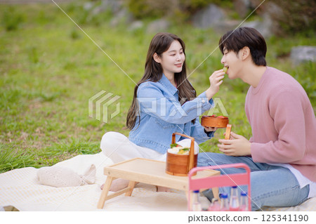 A couple enjoying a date while having a picnic in the park 125341190