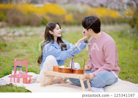 A couple enjoying a date while having a picnic in the park 125341197