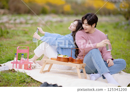 A couple enjoying a date while having a picnic in the park A couple enjoying a date while having a picnic in the park 125341200