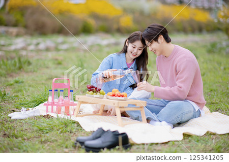 A couple enjoying a date while having a picnic in the park 125341205
