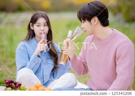 A couple enjoying a date while having a picnic in the park 125341206