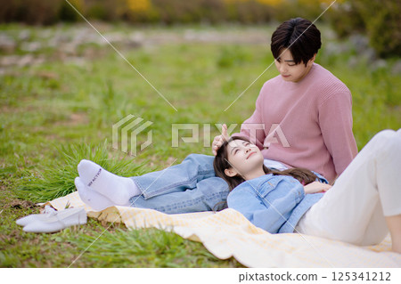A couple enjoying a date while having a picnic in the park 125341212