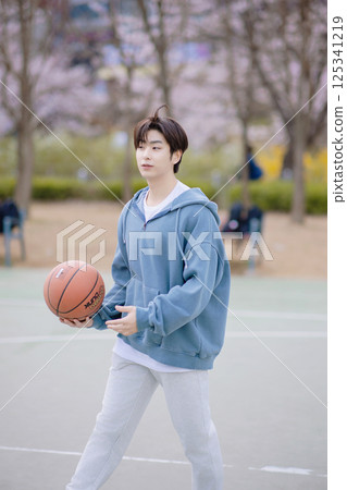 Portrait of a young man playing basketball in the park 125341219
