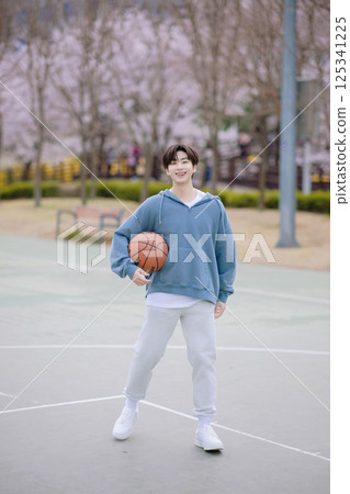 Portrait of a young man playing basketball in the park 125341225