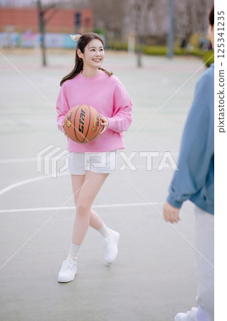 A young couple enjoying a basketball date in the park 125341235